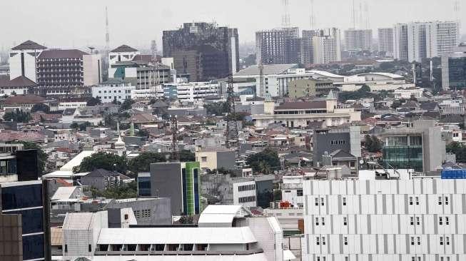 Deretan rumah penduduk dengan latar gedung apartemen dan perkantoran di Jakarta, Selasa (31/1).