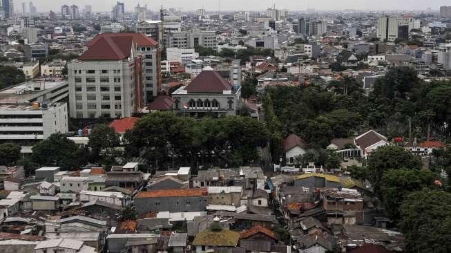 Deretan rumah penduduk dengan latar gedung apartemen dan perkantoran di Jakarta, Selasa (31/1).