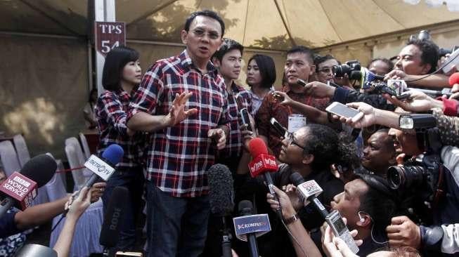 Calon Gubernur Petahana Basuki Tjahja Purnama (Ahok) beserta istrinya Veronica dan putra sulungnya Nicolas memberikan hak suara di TPS 54, Kompleks Pantai Indah Mutiara, Penjaringan, Jakarta, Rabu (15/2).