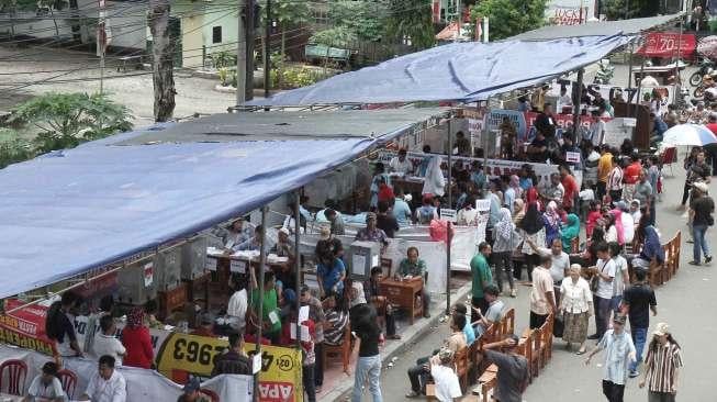 Ratusan warga menggunakan hak pilih di Tempat Pemungutan Suara 01 sampai 14 yang didirikan di luar komplek TNI saat Pemilihan Gubernur DKI Jakarta di Kelurahan Kebon Manggis, Kecamatan Matraman, Jakarta, Rabu (15/2).