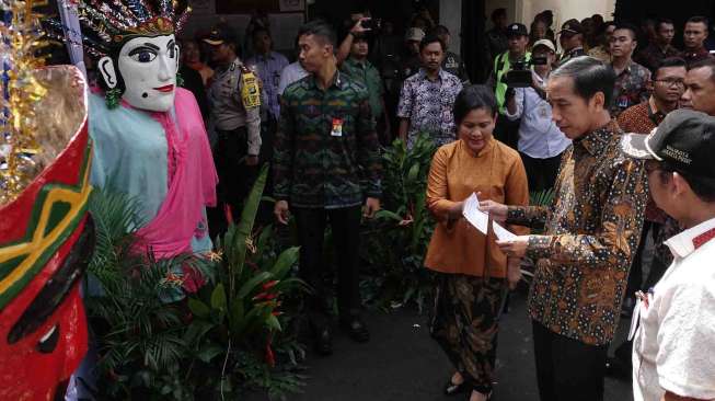 Presiden Joko Widodo didampingi istri, Iriana Widodo menggunakan hak suara dalam Pilkada DKI Jakarta di TPS 04 Gambir, Jakarta, Rabu (15/2). 