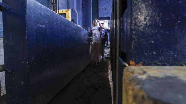 Warga melintasi lorong setapak untuk menyeberang jalan di pintu air kawasan Petamburan, Jakarta, Senin (20/2).