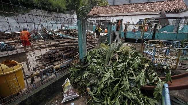 Petugas PPSU membersihkan sisa puing reruntuhan bangunan sekolah di Jalan H Samali, Gang Ayub, Pejaten Barat, Pasar Minggu, Jakarta, Rabu (22/2)