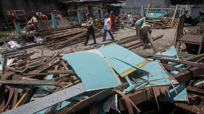 Petugas PPSU membersihkan sisa puing reruntuhan bangunan sekolah di Jalan H Samali, Gang Ayub, Pejaten Barat, Pasar Minggu, Jakarta, Rabu (22/2)