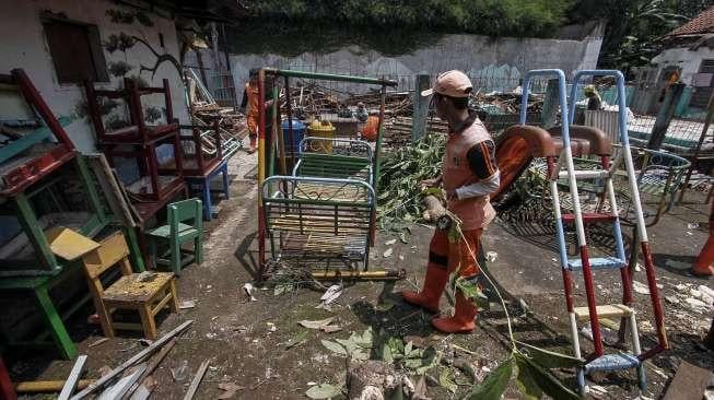 Petugas PPSU membersihkan sisa puing reruntuhan bangunan sekolah di Jalan H Samali, Gang Ayub, Pejaten Barat, Pasar Minggu, Jakarta, Rabu (22/2)