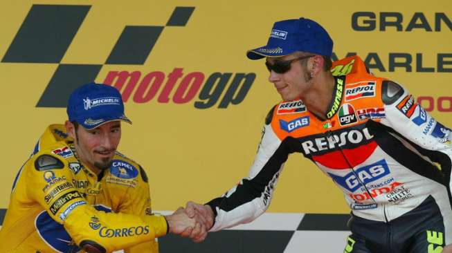 Max Biaggi dan Valentino Rossi tampak bersalaman di podium tanpa saling tatap muka di Jerez, Spanyol, (11/5/2003) [AFP/Pierre-Philippe Marcou]