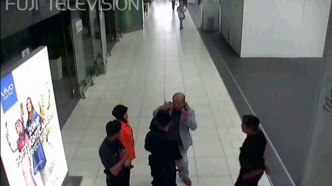 Cuplikan tayangan CCTV menunjukkan Kim Jong Nam (mengenakan setelan abu-abu) sedang berbicara dengan petugas Bandaran Internasional Kuala Lumpur pada 13 Februari lalu (AFP/Fuji TV).