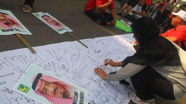 Gabungan Pemuda Islam Indonesia mengumpulkan tanda tangan dukungan untuk kedatangan Raja Salman di kawasan Bunderan Hotel Indonesia, Jakarta, Minggu (26/2/2017). [Suara.com/Oke Atmaja]