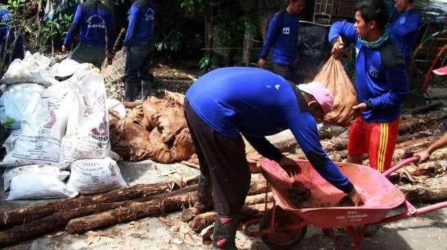 Pekerja Harian Lepas (PHL) Dinas Tata Air DKI Jakarta membetulkan turap air yang longsor di kawasan Matraman, Jakarta, Minggu (26/2/2017). [Suara.com/Oke Atmaja]