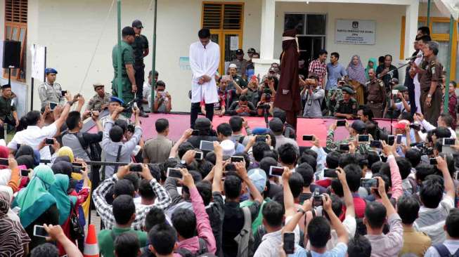 Terpidana pelanggar peraturan daerah (Qanun) Syariat Islam menjalani hukuman cambuk di halaman Masjid Rukoh, Banda Aceh, Aceh, Senin (27/2).