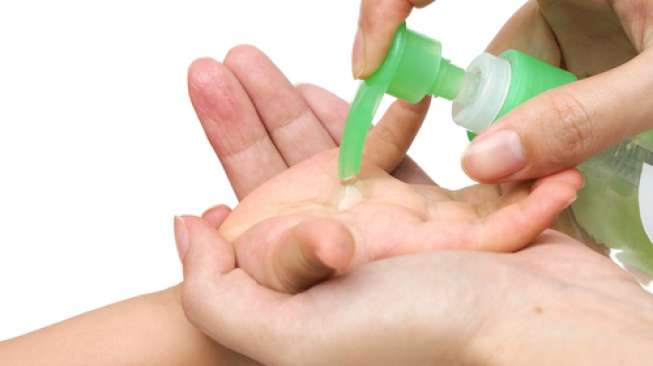 Tangan seorang anak diberikan cairan 'hand sanitiser' oleh orang dewasa. [shutterstock]