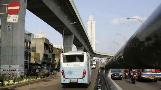 Pekerja menyelesaikan pembangunan Jalan Layang Non Tol (JLNT) Tendean-Ciledug di Halte Bus Transjakarta Koridor 13 di Kawasan Mampang, Jakarta, Sabtu (11/3/2017). [Suara.com/Oke Atmaja]