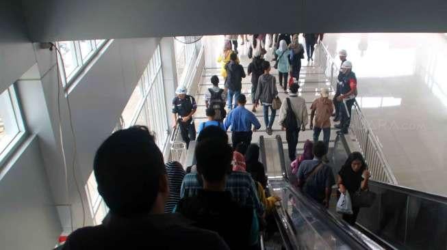 Sejumlah calon penumpang kereta berjalan melalui Jembatan Penyeberangan Orang (JPO) di Stasiun Tanah Abang, Jakarta, Rabu (15/3/2017). [Suara.com/Oke Atmaja]