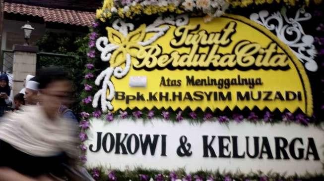 Karangan bunga dukacita dari Presiden Joko Widodo dan keluarga di acara pemakaman KH Hasyim Muzadi di Kompleks Pondok Pesantren Al Hikam, Beji, Depok, Jawa Barat, Kamis (16/3/2017). [Suara.com/Oke Atmaja]