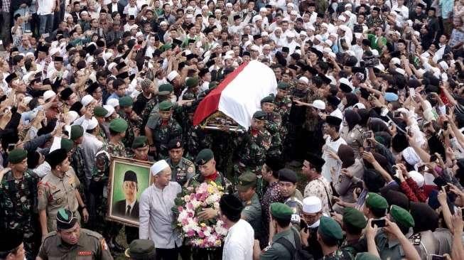 Prajurit TNI menggotong peti jenazah KH Hasyim Muzadi saat akan dimakamkan di Kompleks Pondok Pesantren Al Hikam, Beji, Depok, Jawa Barat, Kamis (16/3/2017). [Suara.com/Oke Atmaja]