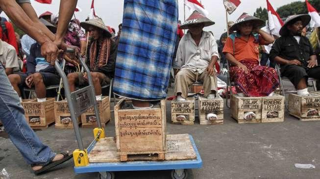 Puluhan petani dari kawasan Pegunungan Kendeng kembali melakukan aksi protes dengan mengecor kaki menggunakan semen di depan Istana Negara, Jakarta, Kamis (16/3/2017). [Suara.com/Kurniawan Mas'ud]