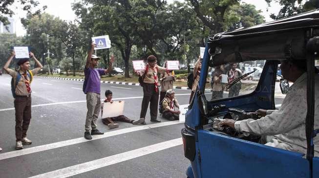 Aktivis Koalisi Pejalan Kaki dan Pramuka melakukan aksi peduli pejalan kaki di kawasan pedestrian Jalan Merdeka Selatan, Jakarta, Jumat (17/3).