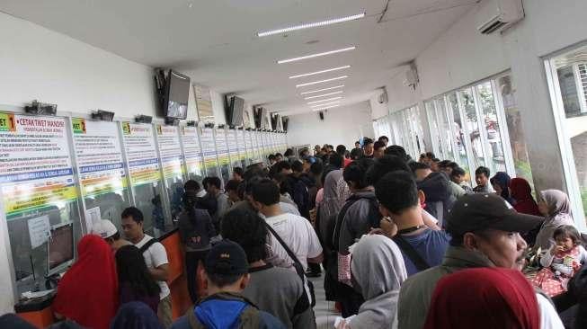 Calon penumpang antre saat melakukan pemesanan tiket kereta api di loket Stasiun Senen, Jakarta, Sabtu (18/3).