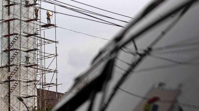 Pekerja melakukan perawatan gedung kantor pusat Pertamina, di Jakarta, Rabu (22/03).