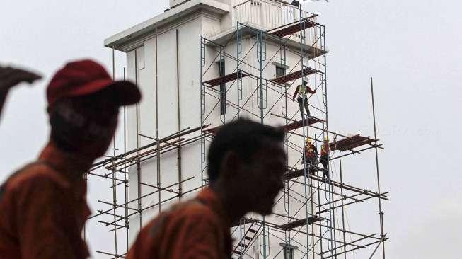 Pekerja melakukan perawatan gedung kantor pusat Pertamina, di Jakarta, Rabu (22/03).