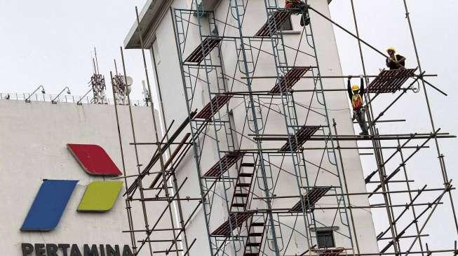 Pekerja melakukan perawatan gedung kantor pusat Pertamina, di Jakarta, Rabu (22/03).