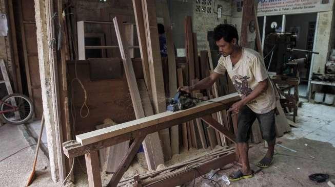 Pekerja menyelesaikan kerajinan kayu di sentra produksi kusen di kawasan Bukit Duri, Jakarta, Kamis (23/3).