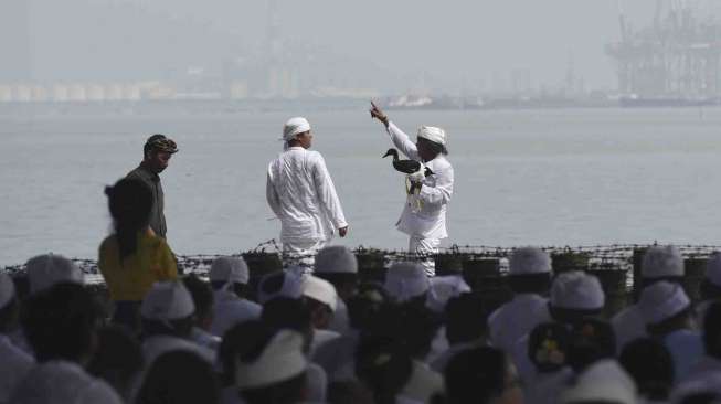 Umat Hindu melakukan upacara Melasti di Pantai Arafuru, Surabaya, Jawa Timur, Minggu (26/3).