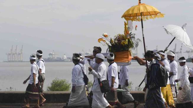 Umat Hindu melakukan upacara Melasti di Pantai Arafuru, Surabaya, Jawa Timur, Minggu (26/3).