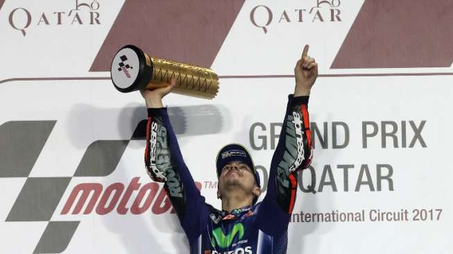 Pebalap MotoGP dari tim Movistar Yamaha, Maverick Vinales, merayakan kemenangannya di Sirkuit Losail, Qatar, Minggu (26/3/2017). [AFP/Karim Jaafar]