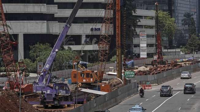 Pekerja menyelesaikan proyek pembangunan MRT di Jalan Jenderal Sudirman, Jakarta, Selasa (28/3/2017), di mana sementara itu posisi utang pemerintah tercatat naik Rp39,95 triliun dibanding Januari 2017. [Suara.com/Kurniawan Mas'ud]