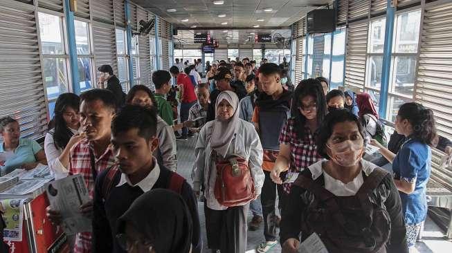 Sejumlah penumpang menggunakan jasa TransJakarta di Halte Harmoni, Jakarta, Selasa (28/3/2017). [Suara.com/Kurniawan Mas'ud]