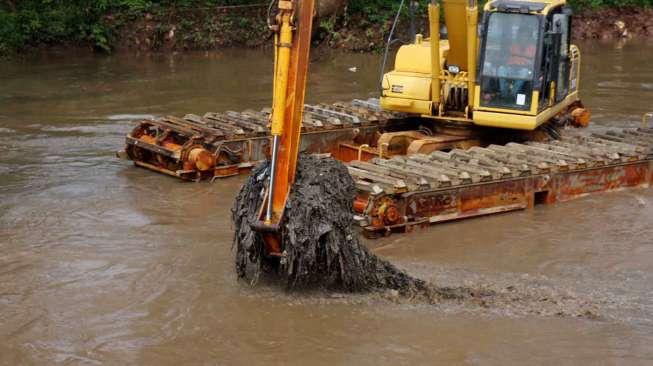 Pekerja dengan alat berat/ekskavator dari Dinas Tata Air DKI Jakarta mengeruk endapan lumpur bercampur sampah di Kali Pesanggrahan, Jakarta, Sabtu (1/4/2017). [Suara.com/Oke Atmaja]