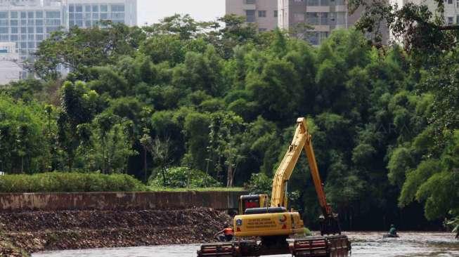 Alat berat/ekskavator dari Dinas Tata Air DKI Jakarta dikerahkan untuk mengeruk endapan lumpur bercampur sampah di Kali Pesanggrahan, Jakarta, Sabtu (1/4/2017). [Suara.com/Oke Atmaja]