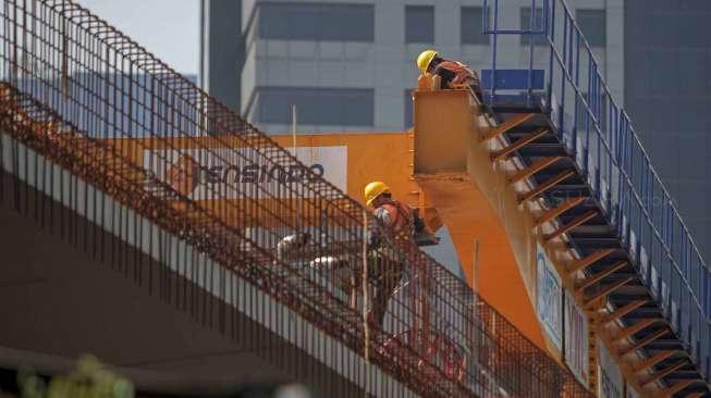 Sejumlah pekerja menyelesaikan pengerjaan jembatan Simpang Susun Semanggi, Jakarta, Selasa (4/4/2017), sembari memastikan terhindar dari kecelakaan kerja. [Suara.com/Kurniawan Mas'ud]
