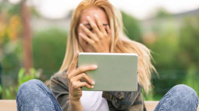 Ilustrasi seorang perempuan sedang menonton film porno di gadgetnya. (Shutterstock)