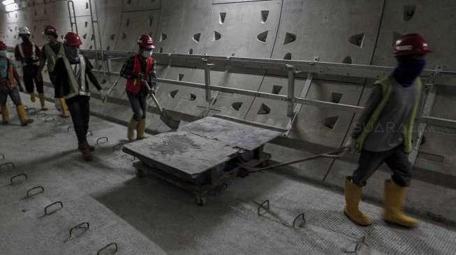 Pekerja menyelesaikan proyek pembangunan Mass Rapid Transit (MRT) tahap I koridor selatan-utara yang menghubungkan kawasan Lebak Bulus hingga Bundaran HI, Jakarta, Kamis (6/4).