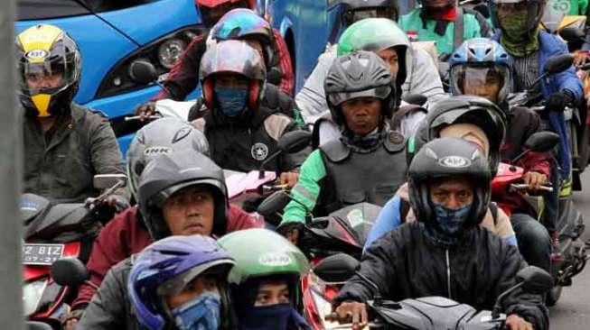 Sejumlah pengendara sepeda motor memadati jalan di samping proyek pengerjaan jembatan layang (fly over) Pancoran, Jalan Gatot Subroto, Jakarta, Sabtu (8/4/2017). [Suara.com/Oke Atmaja]