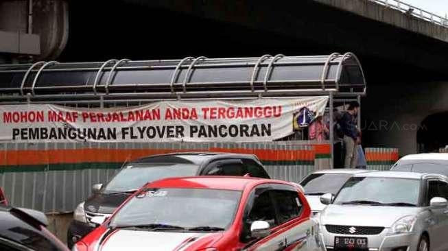 Spanduk permohonan maaf  di samping proyek pengerjaan jembatan layang (fly over) Pancoran, Jalan Gatot Subroto, Jakarta, Sabtu (8/4/2017). [Suara.com/Oke Atmaja]