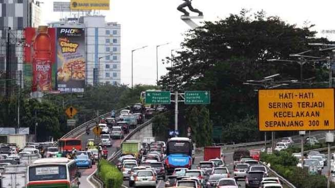 Sejumlah kendaraan melintasi jalan di samping proyek pengerjaan jembatan layang (fly over) Pancoran, Jalan Gatot Subroto, Jakarta, Sabtu (8/4/2017). Proyek itu menyebabkan kemacetan arus lalu lintas. [Suara.com/Oke Atmaja]