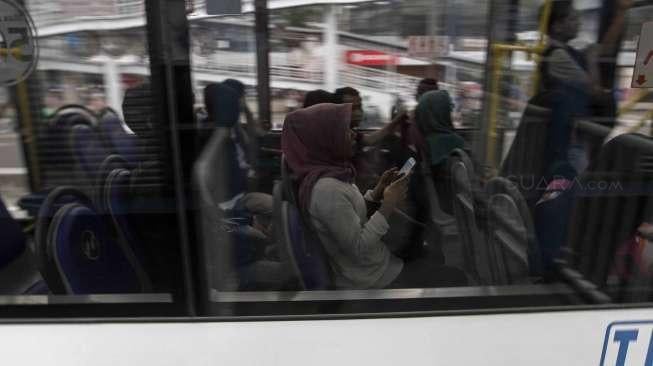 Penumpang menggunakan jasa Bus Transjakarta Maxi di Jakarta, Senin (10/4).