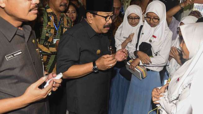 Gubernur Jawa Timur Soekarwo (tengah) berdoa bersama siswa yang akan mengikuti Ujian Nasional Berbasis Komputer (UNBK) saat sidak UNBK di SMAN 5 Surabaya, Jawa Timur, Senin (10/4).