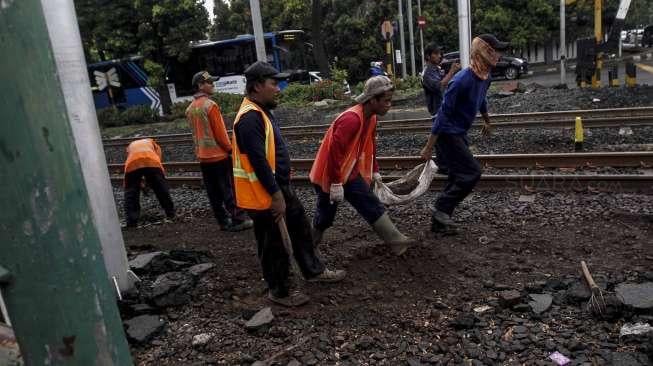 Pekerja melakukan panambalan jalur perlintasan rel kerera api di kawasan Latuharhari, Menteng, Jakarta, Selasa (11/4).