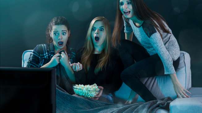 Tiga orang perempuan sedang menonton film horor. [shutterstock]
