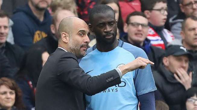 Pemain Man City Yaya Toure mendengarkan instruksi manajer Josep Guardiola [AFP]