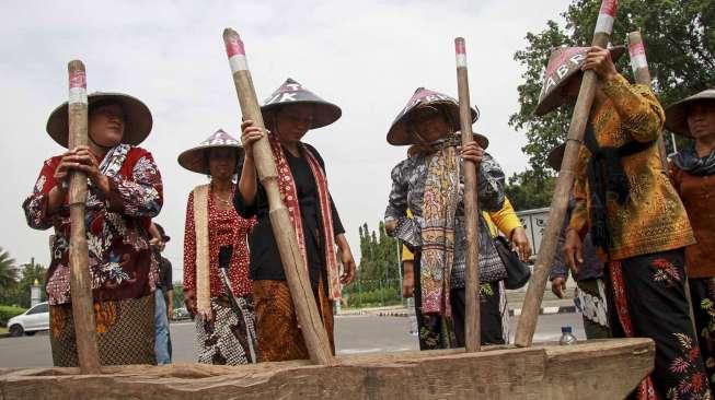 Sejumlah petani Pegunungan Kendeng menabuh lesung saat menggelar aksi di depan Istana Merdeka, Jakarta, Rabu (12/4).