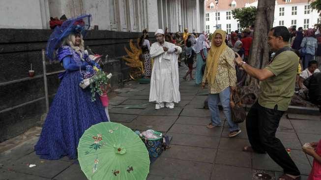 Warga memanfaatkan hari libur panjang di Kota Tua, Jakarta, Jumat (14/4).