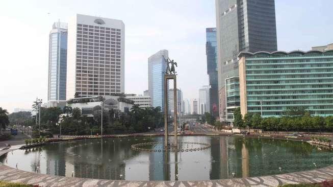 Sejumlah kendaraan melintas di kawasan Bundaran Hotel Indonesia, Jakarta, Jumat (14/4).