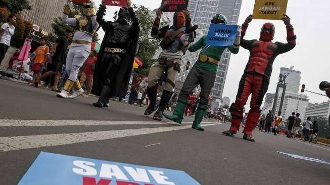 Para aktivis dari Koalisi Masyarakat Anti Korupsi menggelar aksi teatrikal ala superhero demi membela KPK di ajang Car Free Day, kawasan Bundaran HI, Jakarta, Minggu (16/4/2017). [Suara.com/Kurniawan Mas'ud]