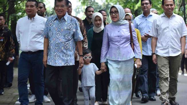 Wakil Presiden Jusuf Kalla didampingi istri Mufidah Jusuf Kalla dan keluarga memberikan suara pada Pilkada DKI Jakarta putaran kedua di TPS 3 Pulo, Kebayoran Baru, Jakarta, Rabu (19/4).