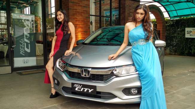 Dua orang model berfoto di depan sebuah mobil Honda City (Suara.com/Insan Akbar Krisnamusi).